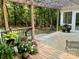 Inviting outdoor patio with wood flooring, lush greenery, and comfortable seating, creating a serene retreat at 7408 Mockingbird Ln, Waxhaw, NC 28173