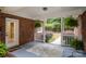 Charming covered porch with brick siding, a patterned rug, and a view of the landscaped yard, offering a cozy entrance at 7408 Mockingbird Ln, Waxhaw, NC 28173