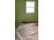 Bedroom view with a window, showing damaged floors and green walls at 7705 Stone Canyon Ln, Charlotte, NC 28227