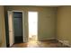 Bedroom with view into the bathroom and closet, damaged floors, and yellow walls at 7705 Stone Canyon Ln, Charlotte, NC 28227