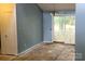 Dining room with open slider door to the deck, chandelier, damaged floors, and blue walls at 7705 Stone Canyon Ln, Charlotte, NC 28227