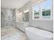 Luxurious primary bathroom with marble tile, glass shower, soaking tub, and dual vanity at 822 River Oaks Ln, Charlotte, NC 28226