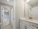 Bathroom featuring white marble floors, gold hardware, white cabinets and a large mirror at 822 River Oaks Ln, Charlotte, NC 28226