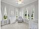 Light and airy Bedroom features a crib, dresser, and comfortable seating area near the windows at 822 River Oaks Ln, Charlotte, NC 28226