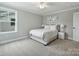 Bedroom with neutral-colored walls and carpet, features a ceiling fan and a bed with a white comforter at 822 River Oaks Ln, Charlotte, NC 28226