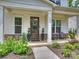 Inviting front porch with stone accents, craftsman columns, and a stained wood front door with transom window at 822 River Oaks Ln, Charlotte, NC 28226