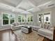 Bright living room with large sectional sofa, coffered ceilings, and expansive windows offering wooded views at 822 River Oaks Ln, Charlotte, NC 28226