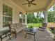 Covered patio area, furnished with comfortable seating overlooking the green backyard at 822 River Oaks Ln, Charlotte, NC 28226