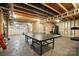 Unfinished basement showcasing exposed beams, a ping pong table, and workout equipment at 8427 Penton Pl, Harrisburg, NC 28075