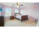 Comfortable bedroom with a full-sized bed, neutral carpet, and bright, shuttered windows at 8427 Penton Pl, Harrisburg, NC 28075