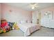 Cozy bedroom with a twin bed, plush toys, and soft pink walls at 8427 Penton Pl, Harrisburg, NC 28075