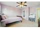 The purple bedroom features a ceiling fan and ample natural light from two large windows at 8427 Penton Pl, Harrisburg, NC 28075