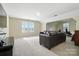 Bright bonus room with plush carpeting, a comfortable leather sofa, and bright natural light at 8427 Penton Pl, Harrisburg, NC 28075