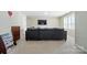 A well-lit bonus room featuring a plush sofa, neutral carpet, and a wall-mounted television at 8427 Penton Pl, Harrisburg, NC 28075