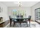 Bright dining room with hardwood floors, decorative rug, and shuttered windows at 8427 Penton Pl, Harrisburg, NC 28075