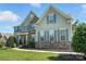 Charming home featuring gray siding, stone accents, manicured lawn, and gray shutters at 8427 Penton Pl, Harrisburg, NC 28075