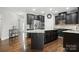 Open kitchen with granite countertops, stainless steel appliances and dark wood cabinets at 8427 Penton Pl, Harrisburg, NC 28075