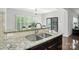Close-up view of a granite countertop with a stainless steel sink and faucet at 8427 Penton Pl, Harrisburg, NC 28075