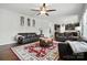 Spacious living room with hardwood floors, ceiling fan, and view into the kitchen at 8427 Penton Pl, Harrisburg, NC 28075