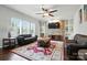 Cozy living room features a ceiling fan, stone fireplace and built-in shelves at 8427 Penton Pl, Harrisburg, NC 28075