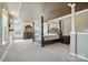 Bright main bedroom with a four-poster bed, large dresser, and abundant natural light at 8427 Penton Pl, Harrisburg, NC 28075
