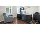 Well-lit home office with hardwood floors and a gray upholstered chair at 8427 Penton Pl, Harrisburg, NC 28075