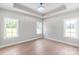 Bright bedroom features tray ceiling, hardwood floors, and abundant natural light from three windows at 1010 Oneil Dr, Monroe, NC 28112