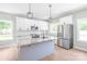 Modern kitchen boasts white cabinets, granite countertops, stainless steel appliances, and ample natural light at 1010 Oneil Dr, Monroe, NC 28112