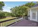 Wood deck overlooking a spacious, fenced in backyard with lush trees at 10121 Edgecliff Rd, Huntersville, NC 28078