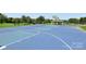 Full basketball court with blue surfacing, surrounded by greenery and trees in a community park at 10121 Edgecliff Rd, Huntersville, NC 28078