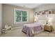 Cozy bedroom with a light purple blanket, open shelving, and a bright window at 10121 Edgecliff Rd, Huntersville, NC 28078