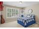 Neutral bedroom featuring a blue plaid bedspread, a corner shelf, and a bright window at 10121 Edgecliff Rd, Huntersville, NC 28078