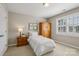 Bright bedroom with wooden dresser, neutral walls, and window with plantation shutters at 10121 Edgecliff Rd, Huntersville, NC 28078