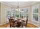 Cozy dining area featuring a round table, hardwood floors, and large window with shutters at 10121 Edgecliff Rd, Huntersville, NC 28078