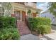 Close-up of the front porch with brick steps and lush greenery surrounding the entrance at 10121 Edgecliff Rd, Huntersville, NC 28078