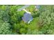 Aerial view of a brick home with a blue deck, surrounded by lush greenery and mature trees in a peaceful neighborhood at 1069 Westlake Dr, Kannapolis, NC 28081