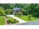 Elevated view of a well-maintained brick home with an attached two-car garage, lush lawns, and a private, wooded lot at 1069 Westlake Dr, Kannapolis, NC 28081