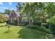 Brick home with well-manicured lawn and mature landscaping in a lush, green setting at 1069 Westlake Dr, Kannapolis, NC 28081