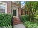 Classic brick home entrance with green door, decorative plants, and manicured bushes at 1069 Westlake Dr, Kannapolis, NC 28081