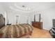 Bright main bedroom with a tray ceiling, hardwood floors, and a large bed, creating a peaceful retreat at 1069 Westlake Dr, Kannapolis, NC 28081