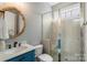 Bathroom features a glass shower, blue vanity, decorative mirror and great lighting at 11806 Stirling Field Dr, Pineville, NC 28134