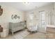 Charming Bedroom with floral wallpaper, a gray crib, and a comfortable rocking chair at 11806 Stirling Field Dr, Pineville, NC 28134