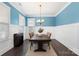 Dining room features blue accent wall, wainscotting, wood table, chandelier, and natural light at 11806 Stirling Field Dr, Pineville, NC 28134