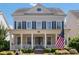 Inviting two-story home with a classic front porch and an American flag displayed proudly at 11806 Stirling Field Dr, Pineville, NC 28134