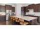 Modern kitchen featuring a large island, stainless steel appliances, and dark wood cabinets at 11806 Stirling Field Dr, Pineville, NC 28134