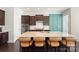 Stylish kitchen island with seating and dark wood cabinets paired with white backsplash at 11806 Stirling Field Dr, Pineville, NC 28134