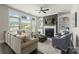 Bright living room with fireplace, built-in shelving, large windows, and comfortable seating at 11806 Stirling Field Dr, Pineville, NC 28134