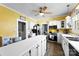 Bright kitchen with yellow walls, white cabinets, and a ceiling fan at 1210 Jackson Rd, Gastonia, NC 28052