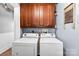 Laundry room with white washer and dryer, wooden cabinets and blue walls at 1210 Jackson Rd, Gastonia, NC 28052