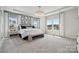 Serene primary bedroom featuring a king bed, tray ceiling, large windows, and elegant decor at 1225 Margo Mannor Dr, Fort Mill, SC 29708